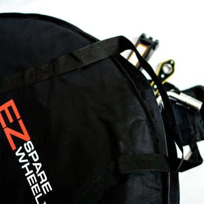 Close-up of a black spare tire bag with 'EZ SPARE WHEEL' text, featuring a telescoping lug wrench and hex sockets.