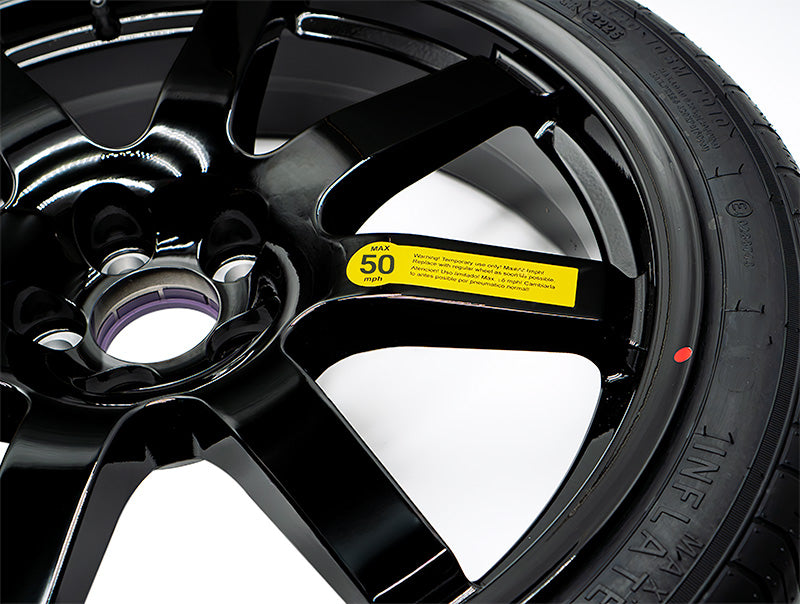 Close-up of EZ Spare tire showing 50 mph warning label and Temporary Use Only' sidewall text on black alloy wheel