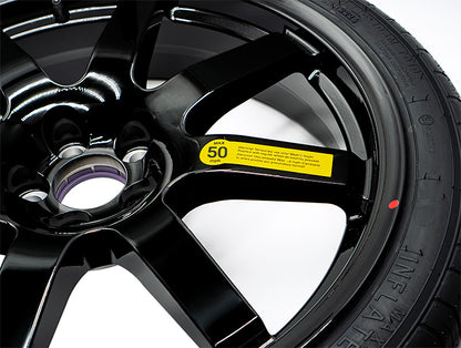 Close-up of EZ Spare tire showing 50 mph warning label and Temporary Use Only' sidewall text on black alloy wheel
