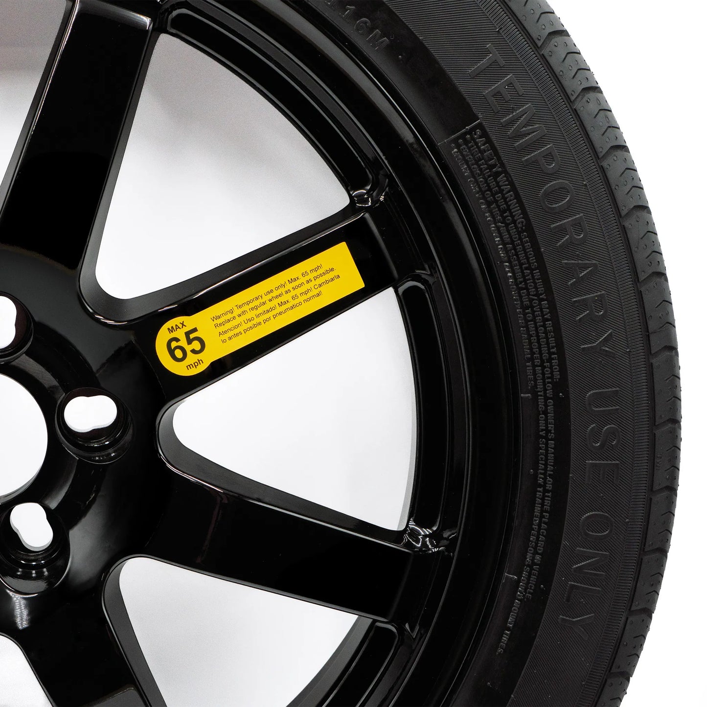Close-up of EZ Spare tire showing 65 mph warning label and 'Temporary Use Only' sidewall text on black alloy wheel